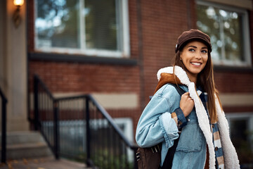 Portrait oh young happy woman outdoors looking away.