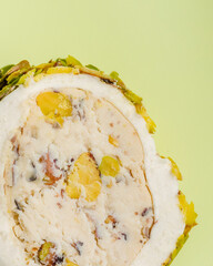 Macro view of a pice of nougat with  nuts on green background