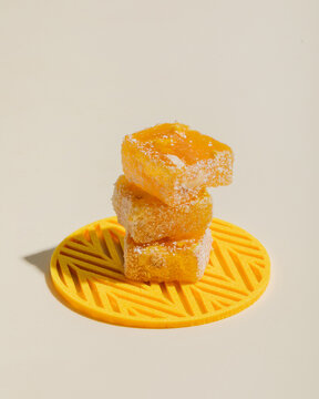 Slices of lemon lucum stand in a stack on yellow plate