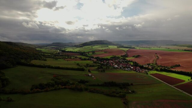 Aer ial view of a German village surrounded by meadows, farmland and forest in Germany.