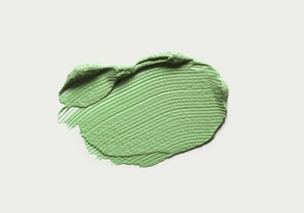 Cosmetic green mask texture smudge isolated on gray background