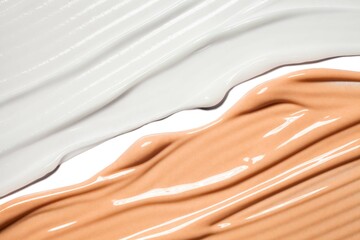 Cosmetic beige foundation and white primer on white isolated background