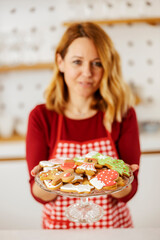 Selective focus on hands holding plate with fresh home made ginger cookies made for christmas eve.