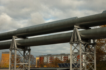 pipeline, in the photo the pipeline is close-up, in the background the city and buildings