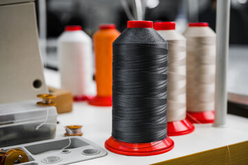 multi-colored bobbins with threads for sewing shoes at a large industrial plant close-up
