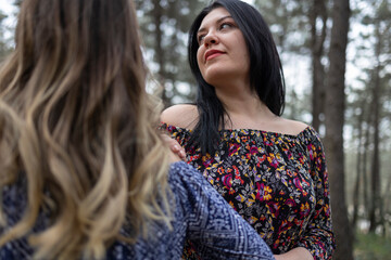 Two girls dressed in ethnic. Forest background. The focus is on the girl who has black hair. Other girl is flu.