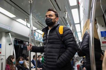 Fototapeta na wymiar A passenger travelling with Turkish metro. He wears black medical mask.
