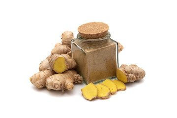 Ginger and a glass bowl with powdered ginger, isolated on white background. Zingiber is a genus that contains the true gingers, plants with medicinal and culinary value in many parts of the world. 