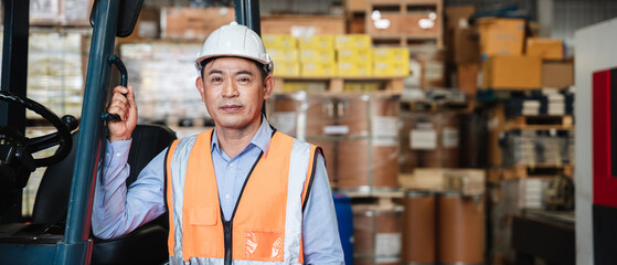 Portrait of a woman working with a forklift in a warehouse with her looking at the camera. © NewSaetiew