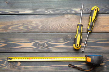Meter measure tape on wooden workbench background with copy space.