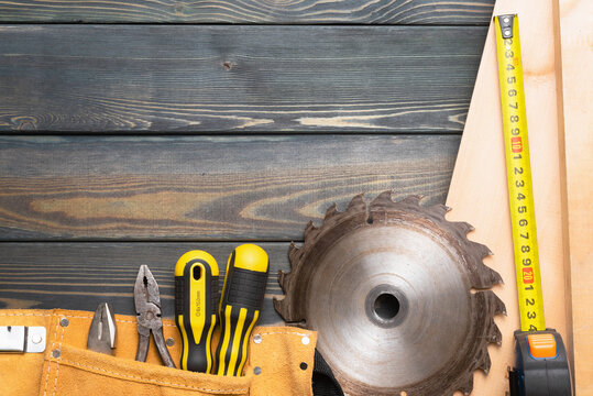 Meter, wooden planks, construction tools and circular saw blade on the carpenter workbench flat lay background with copy space.