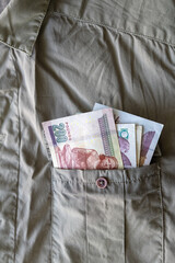 Ägyptische Pfund Banknoten in eine Hemdtasche. Grünes Hemd mit einer Brusttasche voller Banknoten.