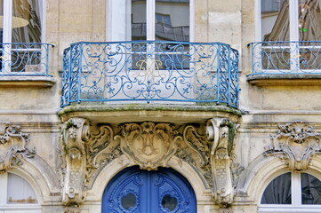 Balcon en fer forgé sur une façade ancienne.
