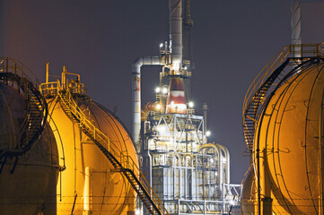 A large oil-refinery plant with Liquefied Natural Gas - LNG - storage tanks