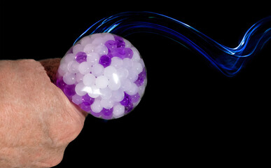 Isolated hand using anti-stress ball. Copy space