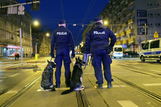 Policjant przewodnik psa podczas zabezpieczenia imprezy masowej.