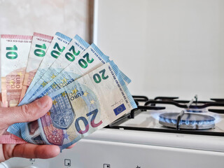 Energy efficiency concept with gas cooker and euro currency – the cost of natural gas is more expensive. Selective focus.