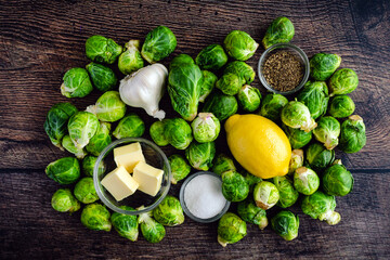 Roasted Brussels Sprouts with Garlic Butter Ingredients on a Wood Background: Raw Brussels sprouts, garlic, and other ingredients for a side dish