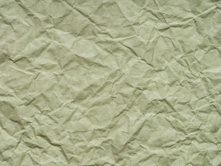 Texture of crumpled green craft paper. Texture, pattern for handcrafts, new year designs decoration, text, lettering, wall screen saver or other art work. Crumpled green paper background top view.