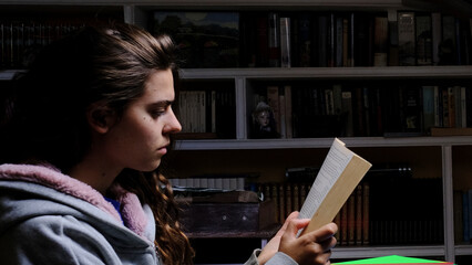 Chica caucásica leyendo en la biblioteca