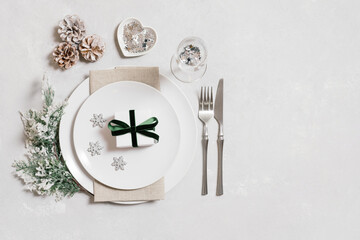 Christmas table setting with New Year decorations on gray background. Copy space, top view, flat lay.