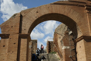 Ostia Antica, Rome, Italy - April 03, 2022, detail of the arch and the brick perimeter wall, in an...