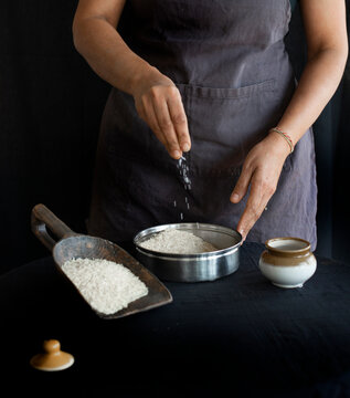 Woman adding salt to rice 