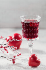 Red cocktail, vodka or liqueur and Heart shape decorations on white background. Happy Valentines day concept.