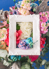 A creative flower arrangement made of colorful flowers and a white retro frame. Minimal spring concept.