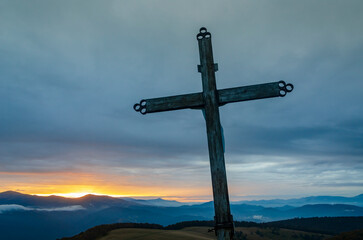 Tilted cross with dramatic sunset sky