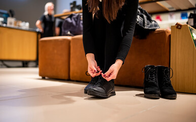 Woman trying black shoes sitting in a shop