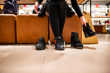 Woman trying black shoes sitting in a shop