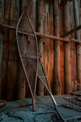 A pair of old Iroquois showshoes leans up against a wooden wall inside a longhouse at Crawford Lake...