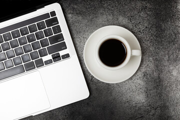 Top view of workspace with laptop and coffee cup on black table. Space for copy space.Place for text. Flat lay