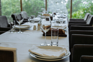 Set table, plates with food, glasses, glasses on a white tablecloth