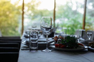 Set table, plates with food, glasses, glasses on a white tablecloth