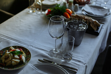 Set table, plates with food, glasses, glasses on a white tablecloth