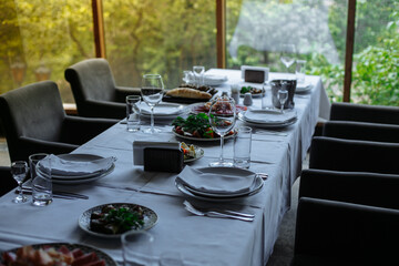Set table, plates with food, glasses, glasses on a white tablecloth