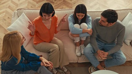 Upset teenager girl with her parents at a psychologist's appointment. Family at psychology session. Psychologist helping young family with a child to solve teenagers problems.