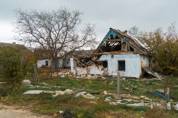 Fototapeta na wymiar Countryside. House destroyed by shelling. War in Ukraine. Russian invasion of Ukraine. Destruction of infrastructure. Terror of the civilian population. War crimes