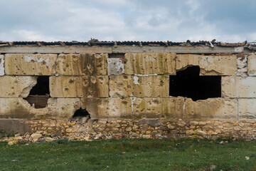 Wall with holes after shelling. War in Ukraine. Russian invasion of Ukraine. Destruction of...