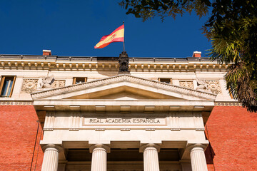 Detail of the tympanum on the building of the Real Spanish Academy (RAE) with flag on top