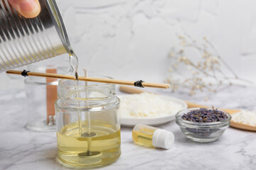 Liquid soy candle wax is poured into a glass jar. Crafting and handmade. Eco friendly decorative element.Close up.