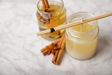 Soy candles handmade with wooden wicks. Handmade craft candles. Vegan product. Glass jars with soy wax on a marble table.