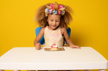 Smiling beauty child girl with birthday cake made five years age isolated on yellow background