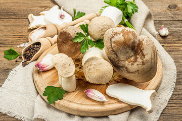 Fresh Pleurotus eryngii mushrooms on wooden background. Raw king oyster eringi with spices and herbs