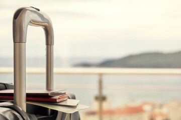 Obraz premium The tourists suitcase, passport and airplane boarding pass in front of the sea