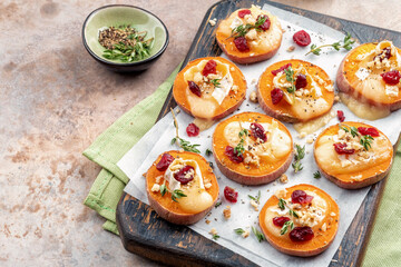 Baked Sweet Potato Rounds topped with brie cheese, cranberry and Walnut. Thanksgiving appetizer bites.