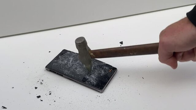Broken phone. Hammer hitting the display breaks the mobile phone. Mobile smartphone with a broken screen. Drop Test. Hammer Durability. Hammer vs mobile display. Smashing the Phone. Breaking display.