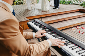 Pianist in a stylish suit plays the piano